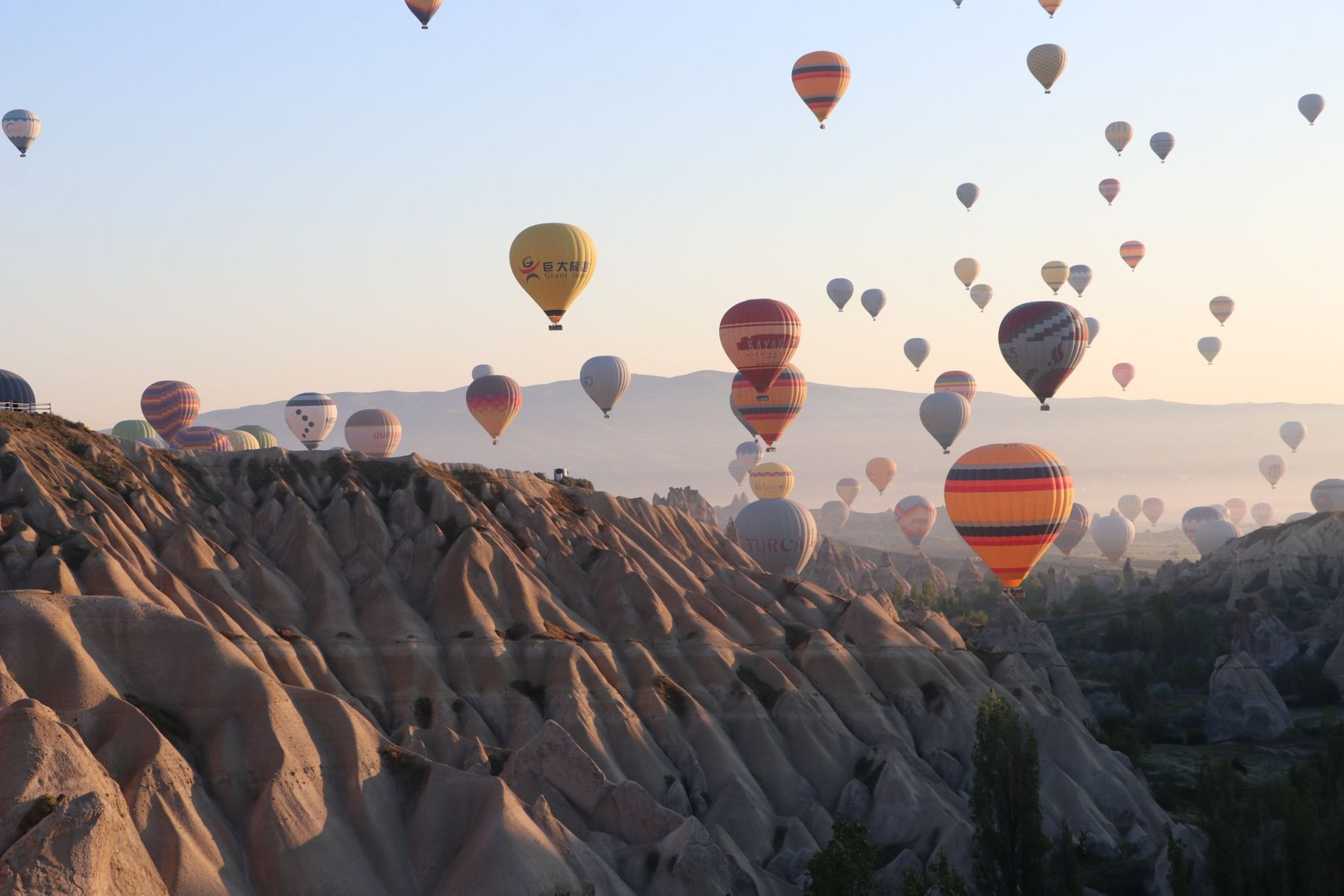 Hot-air balloons rising over the rock valleys of Cappadocia at sunrise